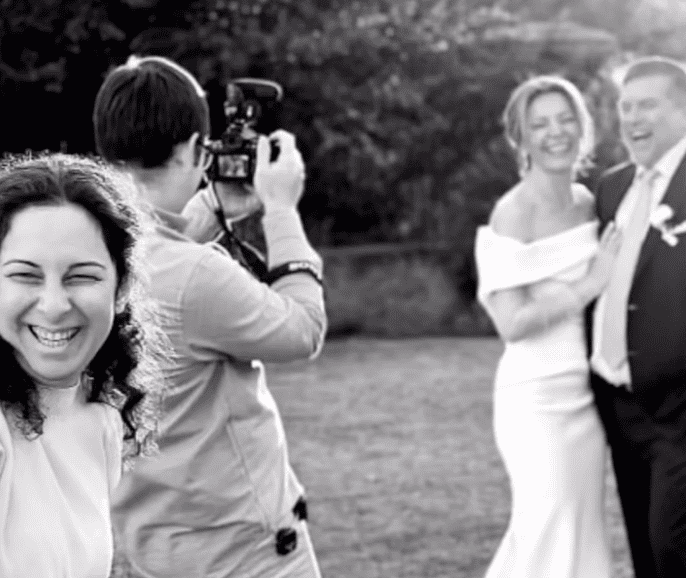 videographer filming laughing couple